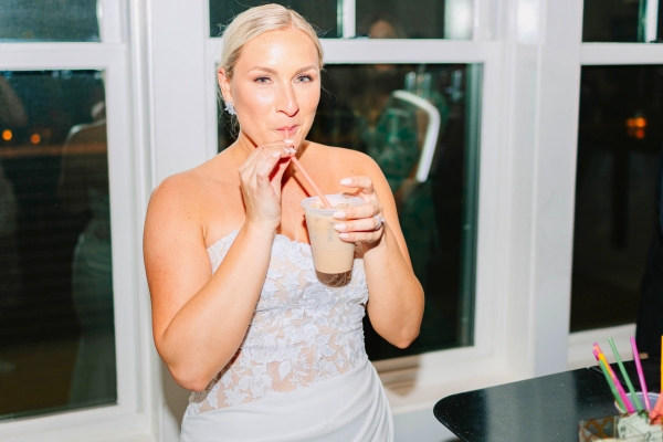 Bride enjoying an iced latte from Espresso Dave’s Coffee Catering's wedding coffee bar during her evening reception