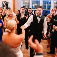 Wedding guests dancing after enjoying drinks from Espresso Dave’s coffee cart