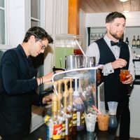 Espresso Dave barista serving coffee to groom and guests at espresso cart during the wedding reception