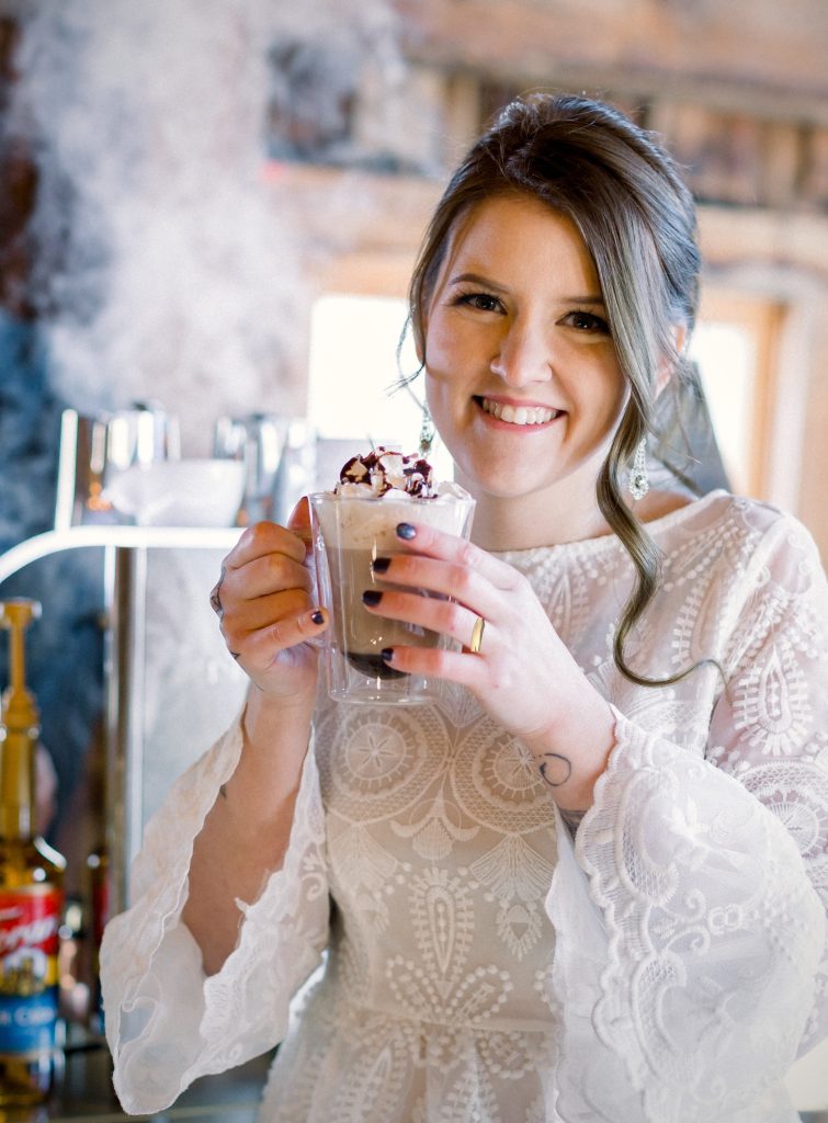 Bride enjoying a handcrafted coffee at a winter wedding espresso bar, illustrating winter wedding ideas with cozy seasonal drinks from Espresso Dave’s.